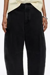 Pantalón vaquero de corte barrel, largo tobillero, tiro medio, con cierre frontal de botón y cremallera, bolsillos delanteros en costura, bolsillos de plastrón en la parte posterior y costadillos laterales.