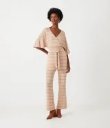 Pantalón largo de tejido de punto con rayas horizontales en tonos beige y marrón claro. El pantalón es de corte flare, con cintura alta y lazo para ajustar.
