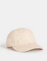 Gorra de béisbol color rosa con estampado de flores blancas y amarillas.