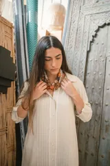 Camisa negra de manga larga con cuello camisero y cierre frontal con botones. Presenta detalles de ribete blanco en cuello, puños y abertura frontal.