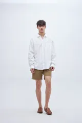 Camisa celeste de algodón, corte regular fit, con cuello solapa clásico, manga larga, bolsillo en el pecho y botones personalizados.