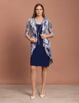 Conjunto de vestido azul marino con chaqueta estampada con motivos florales en tonos plateados y azules.