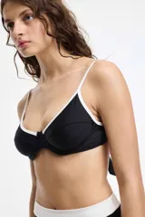 Top de bikini negro con contorno y tirantes blancos.