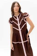 Vestido midi amarillo de lino, con volados en las mangas y detalle de volados y botones a lo largo del frente. Presenta un corte con talle marcado y falda escalonada.