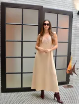 Vestido largo color beige con breteles finos y detalles de encaje en el escote.