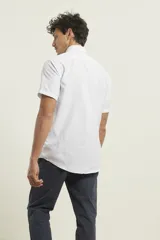 Camisa blanca de manga corta con estampado de lunares pequeños en azul.