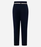 Pantalón de vestir azul marino, de corte zanahoria, con cinturón fino negro con hebilla dorada.