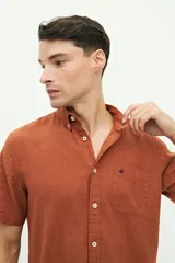 Camisa de manga corta color beige claro, confeccionada en lino y algodón, con fit regular y logo bordado en el pecho.