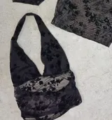 Top negro con estampado floral, escote halter y espalda descubierta.