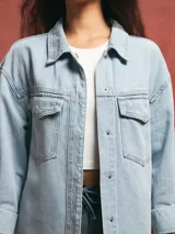 Sobrecamisa celeste de denim con bolsillos frontales y corte holgado.