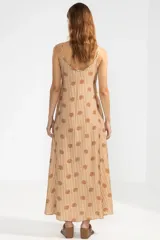 Vestido largo hasta el tobillo con estampado floral color camel, breteles finos y escote en V profundo con detalle de flor en cobre.