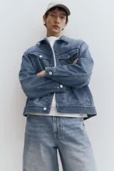 Campera de denim celeste con cuello clásico, cierre frontal con botones metálicos, bolsillos con solapa en el pecho y bolsillos laterales. Corte holgado.
