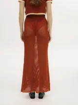 Falda larga de tejido calado color ladrillo, con cintura elástica.