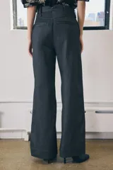 Pantalón de jean azul oscuro, de tiro medio, corte wide leg y bolsillos laterales.