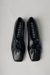 Ballerinas negras de cuero con punta redondeada y detalle de lazo ajustable.