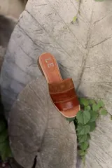 Sandalias de cuero negras con diseño de tiras cruzadas y detalle de elástico en el talón.