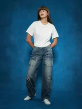 Pantalón de jean cargo de tiro alto, color azul medio desgastado, con corte ancho y bolsillos cargo a los lados de las piernas.