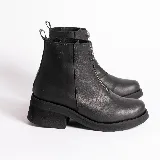 Botas cortas de cuero color marrón con cierre frontal con cremallera, suela de goma y taco bajo.