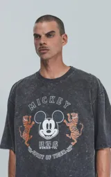 Remera negra con efecto nevado, de manga corta y cuello redondo, con estampado de Mickey Mouse, tigres y texto en inglés y chino.