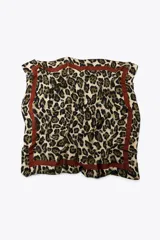 Pañuelo cuadrado de modal con estampado animal print de leopardo en tonos beige, marrón y negro. Tiene una banda perimetral marrón.
