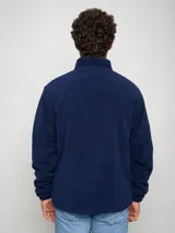 Campera polar oficial del club Nacional, color azul marino con detalles en azul celeste y logo del club.