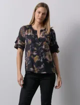 Blusa de gasa estampada con cuello a la base y escote en V. Tiene mangas cortas amplias con sobrecapas.