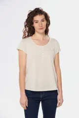 Remera color beige con escote redondo, manga corta, bolsillo en el pecho y cierre parcial con botones.