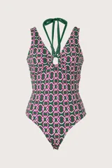 Traje de baño entero verde oscuro con estampado geométrico de círculos en rosa y blanco. Tiene escote en V, breteles halter verdes y aro circular central.