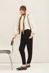 Pantalón negro estilo babucha con elástico en la cintura y cordón de ajuste con terminaciones metálicas. Tiene bolsillos diagonales en el frente y falsos bolsillos ojal en la espalda.
