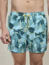 Short de baño con estampado de hojas en tonos celeste, verde y beige. Tiene cintura elástica con cordón ajustable amarillo.