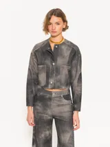 Chaqueta corta de cuero ovino negro con efecto desgastado, cuello mao y cierre frontal con broches metálicos. Presenta bolsillos plaqué en el pecho y corte holgado. Marca JCH.