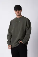 Buzo marrón de algodón rústico con lavado gastado y cuello redondo. Estampa frontal con la frase "Coffee Break". Corte oversize.