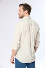 Camisa blanca de lino a rayas celestes, de manga larga, cuello mao y corte slim fit.