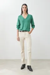 Sweater verde de tejido de punto, con escote en V y mangas largas.