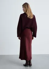 Falda midi de satén color crema, de corte recto y diseño evasé.