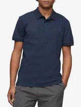 Chomba azul marino de manga corta, con cuello clásico y tapeta de dos botones. Logo de Calvin Klein bordado en el pecho.