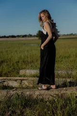 Conjunto de top y pantalón color beige. El top es de breteles anchos, con escote cuadrado y detalle de bordado en el frente. El pantalón es de corte recto y ancho, con bolsillos laterales y cintura con elástico y botones.