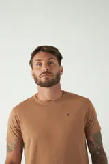 Remera básica color marrón claro, de corte regular, manga corta, cuello redondo y logo bordado en el pecho.