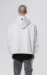 Hoodie corto color gris claro, de corte holgado, con capucha y cordones negros.