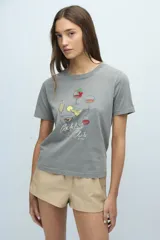 Remera gris con cuello redondo y estampado de copas de cóctel con la frase "Cocktail Club".