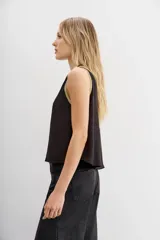 Top sin mangas color rosa pálido con escote en V profundo y vivos en lurex dorado en el contorno del escote y los hombros.