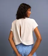 Blusa cropped color gris claro, de corte boxy, cuello redondo y mangas cortas. Presenta abertura en la espalda. Confeccionada en algodón más sostenible.