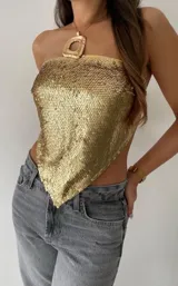 Top dorado con lentejuelas, de corte pañuelo y cuello halter.