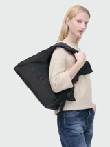 Bolso Marc Jacobs modelo The Bow Nylon Sack, color negro con logo en relieve.