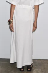 Falda midi blanca de lino, con cintura elástica ajustable con cordones y corte evasé.