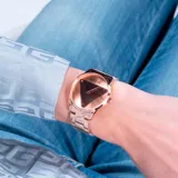 Reloj Guess análogo para mujer, con caja y pulsera de acero color oro rosa, esfera de 36mm con diseño triangular y resistencia al agua de 3 ATM.