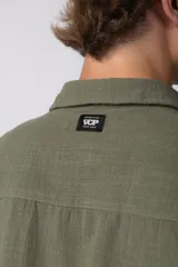 Camisa de lino color blanco, de manga corta, con cuello clásico y cierre frontal con botones.