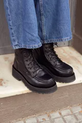 Botas de cuero negras con cordones, cierre lateral con cremallera y suela track de goma.