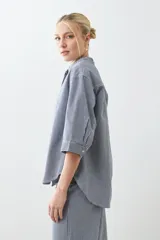 Camisa de jean a rayas verticales azules y blancas, con cuello mao y mangas largas.