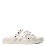 Sandalias bajas color blanco con tiras finas y tachas plateadas.